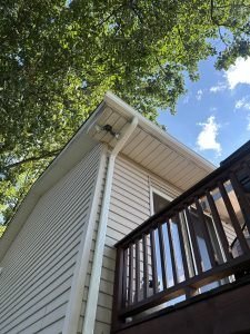 Close-up of new gutter and siding installation above a deck, completed by Birds Eye Roofing